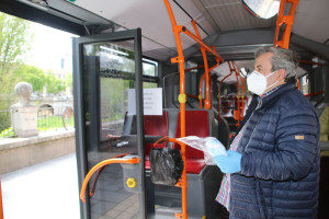 Voluntarios repartiendo mascarillas en los autobuses municipales